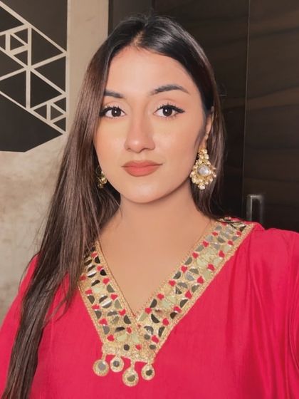 A close-up selfie in a pink kaftan with gorgeous mirror work on the neckline. The focus is on the detailed craftsmanship and festive makeup.