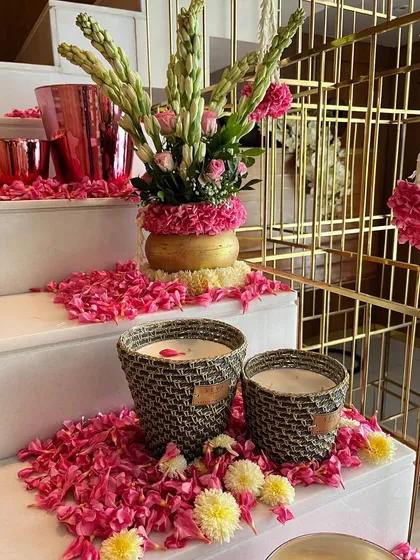More details from our pink, white, and gold Diwali decor. Woven baskets and scattered rose petals complement the floral arrangements, adding texture and a sense of abundance to the staircase landing.