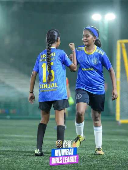 Two teammates share a high-five and a moment of encouragement during a game. This image perfectly illustrates the supportive and positive team culture within our girls' program.