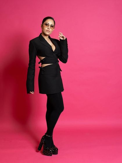 A three-quarter shot from the ELLE feature, highlighting the cutout details of the blazer and the confident posture.