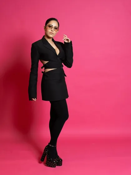 A three-quarter shot from the ELLE feature, highlighting the cutout details of the blazer and the confident posture.