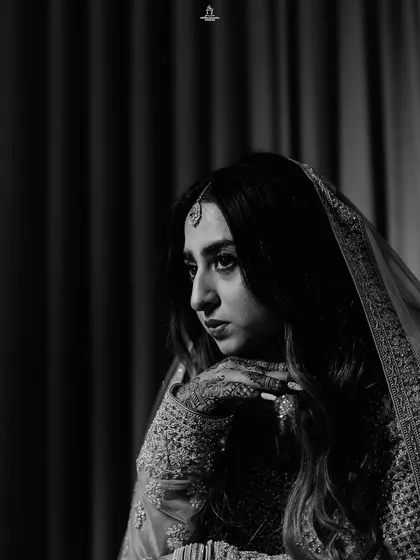 A black and white portrait of a Muslim bride, capturing her pensive and elegant mood.