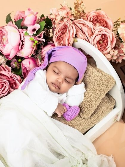 A close-up of the vintage-themed newborn shoot, showing the baby sleeping peacefully. The details in the props add a rich, classic feel.