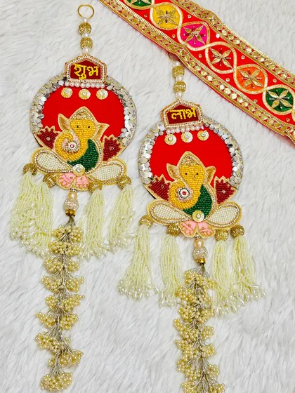 A beautiful Ganesha-themed Shubh Labh set with long, flowing tassels. The red and yellow combination is a classic choice for Diwali.