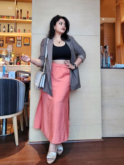 A full-length view of a modern professional outfit. The blazer adds structure, while the flowing skirt maintains a sense of feminine power, suitable for creative and corporate environments alike.