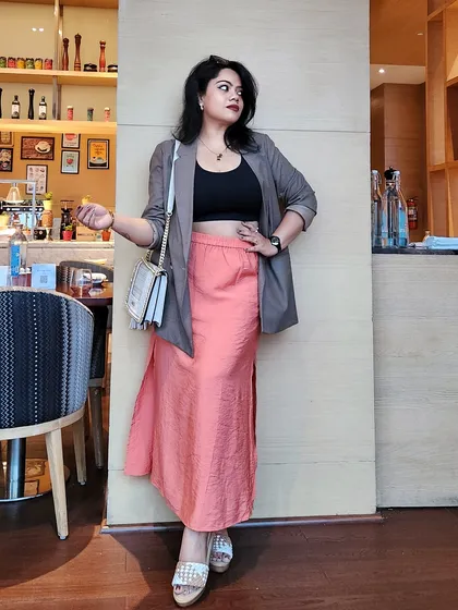 A full-length view of a modern professional outfit. The blazer adds structure, while the flowing skirt maintains a sense of feminine power, suitable for creative and corporate environments alike.
