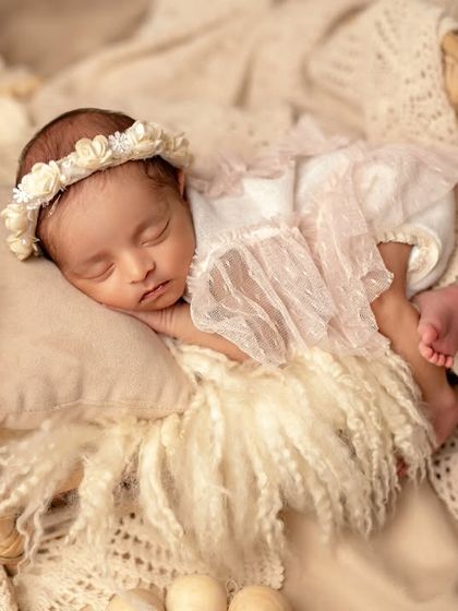 A dreamy boho setup for a sleeping newborn. The natural textures and soft lighting create a calm and serene atmosphere.