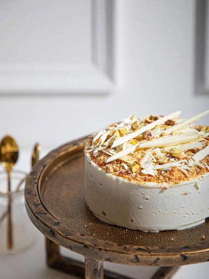 A new look for our all-time favourite Vanilla Raspberry ice cream cake, presented on a stylish golden stand.