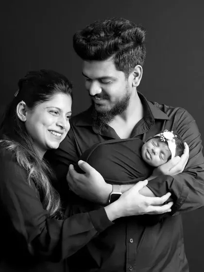 A joyful studio portrait of a couple with their newborn daughter. We work to make sure everyone is comfortable, resulting in genuine smiles and cherished family photographs.