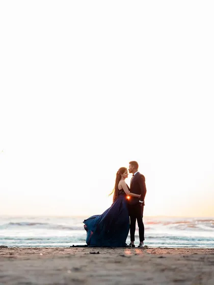 A minimalist and artistic pre-wedding photo using negative space to draw focus to the couple against the vastness of the sea and sky.