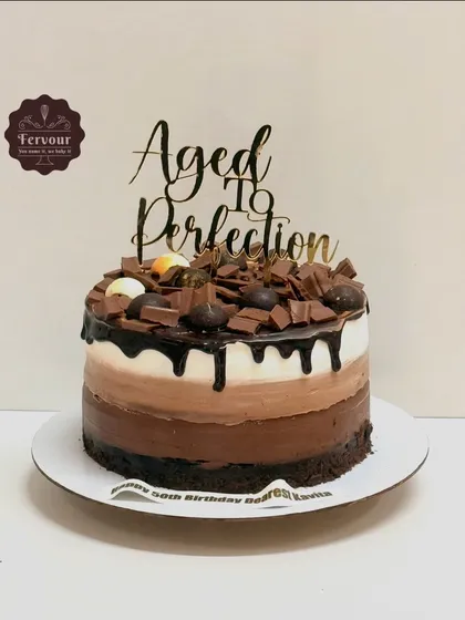 A delicious chocolate truffle cake with a triple-layer mousse covering. The different shades of chocolate mousse create a beautiful ombre effect, topped with chocolate shavings.