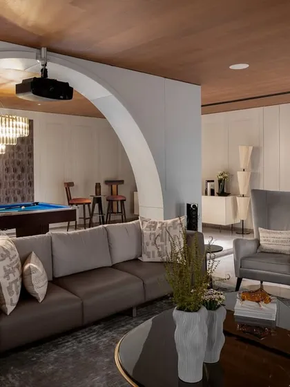 The entertainment lounge is designed for utility and circulation, with comfortable seating and direct access to the outdoor lawns for seamless indoor-outdoor living.