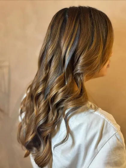 Carmel with slivers of ash. For this look, we used a mix of non-bleach caramel color and added a few fine, bleached highlights to get that cool, ashy contrast.
