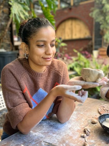 A participant admiring her freshly pinched pot. The retreat is a space to slow down and appreciate the small, beautiful things you can create with your own hands.