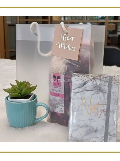 The magic of a simple gift. This 'Best Wishes' hamper includes a succulent in a ceramic mug, a marble-print notebook, and a packet of potpourri.