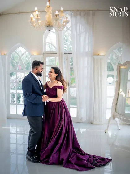 A candid moment of a couple sharing a dance in a beautiful, sun-drenched room. This type of shot adds a sense of movement and joy to a pre-wedding album.