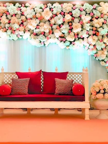 A beautiful floral canopy of peach and white flowers creates a cloud-like effect over this traditional seating arrangement, blending classic and contemporary styles.