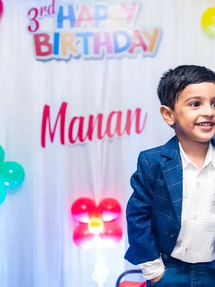 A handsome portrait of the three-year-old birthday boy, looking smart in his blue blazer.