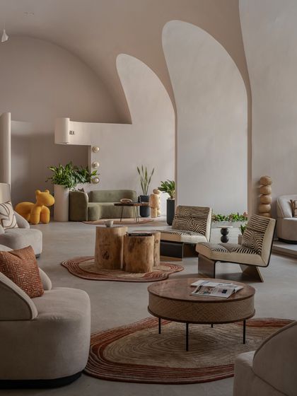 A wider view of the various lounging experiences in the "Vaultz'Up" project. The combination of natural wood, textured rugs, and soft upholstery creates a warm and inviting atmosphere.