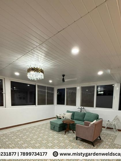 This night shot showcases the interior of the terrace room, featuring a PVC ceiling with integrated lighting, a modern chandelier, and large windows that provide a sense of spaciousness even after dark.
