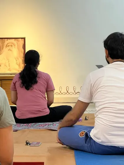 A teacher guides participants from the front of the class, ensuring the practice is transmitted in its purest form.