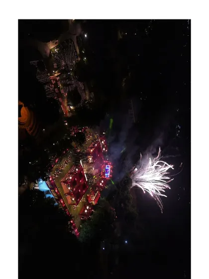A perfectly timed aerial photograph capturing the fireworks display at a night wedding. This perspective shows the entire venue lit up by the celebration.
