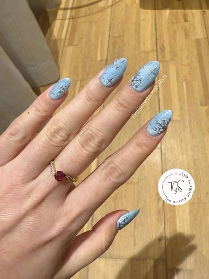 A client's photo of her long, almond-shaped snowflake nails. The design looks stunning and is perfect for the winter season.