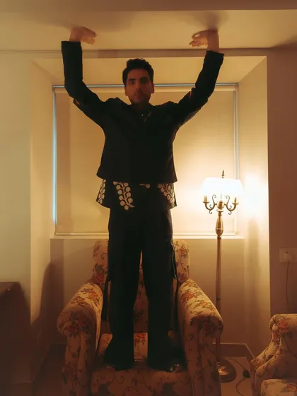 A playful and unconventional pose by Ishwak Singh for his Hindustan Times editorial, standing on an armchair.