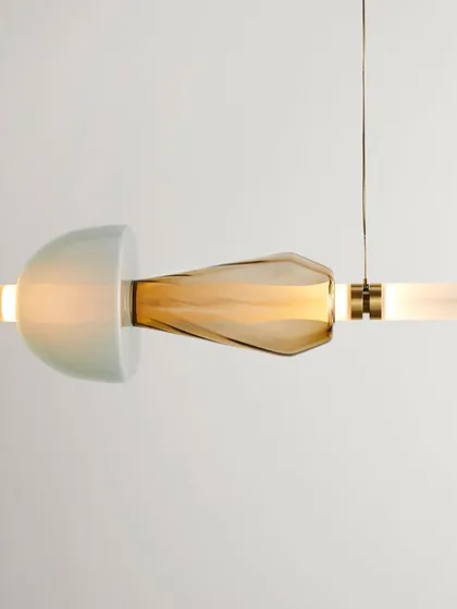 A close-up of a single Luna Kaleido element, showing the combination of a semi-translucent dome and a textured, amber-colored glass piece.