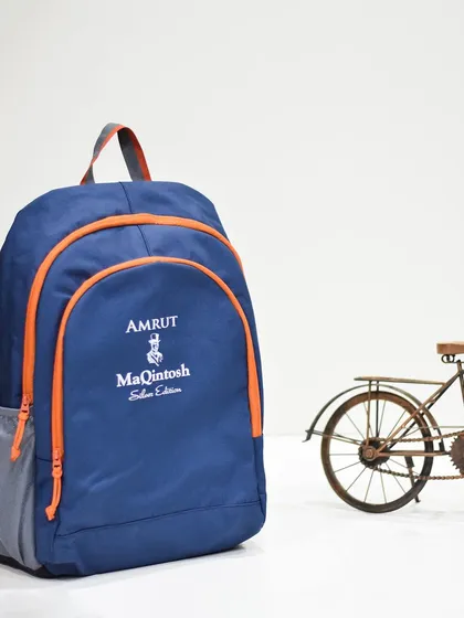 A stylish blue backpack with orange accents, customized for Amrut MaQintosh Silver Edition. The unique color combination makes it stand out.