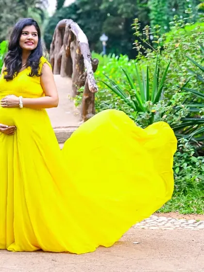 Sunshine in a dress. This mom-to-be looks radiant in a bright yellow gown, the fabric flowing beautifully behind her.