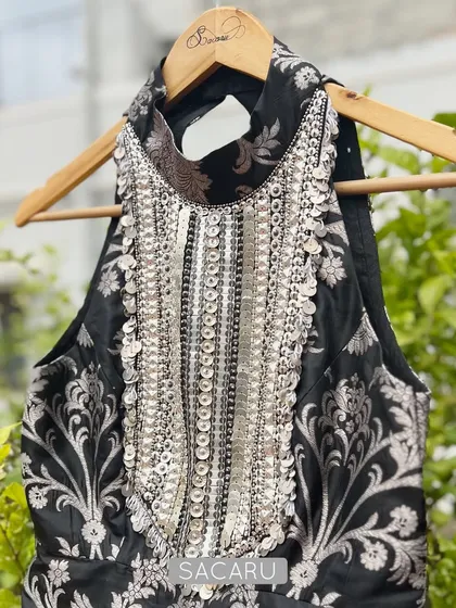 A full view of the black and silver brocade halter top, showcasing its intricate embroidery and modern cut.