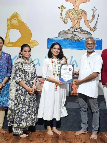 A student receives her certificate for the October Yoga Teacher Training.