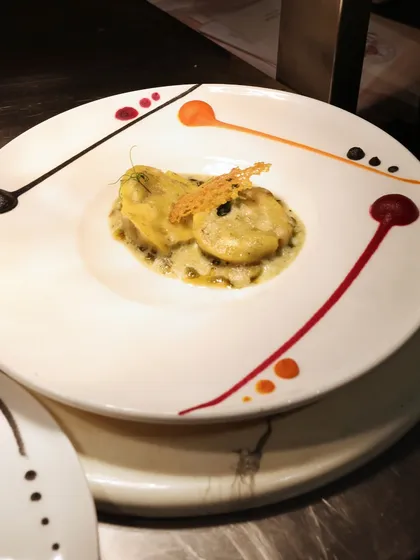 A stunning plate of ravioli, where each piece is a canvas for colourful sauce droplets, creating a playful and artistic presentation.
