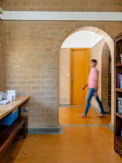 A person walking through the arched hallway in the study area.