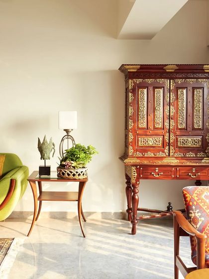 This corner showcases a beautiful blend of textures and styles. The traditional Indian cabinet with brass inlay stands proudly next to a modern sofa, proving that old and new can create a beautiful, cohesive story.