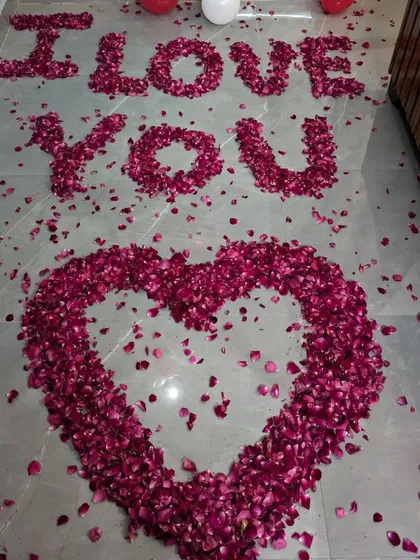 For a grand romantic gesture, I spell out 'I LOVE YOU' on the floor using fresh rose petals, with a large heart shape below it.