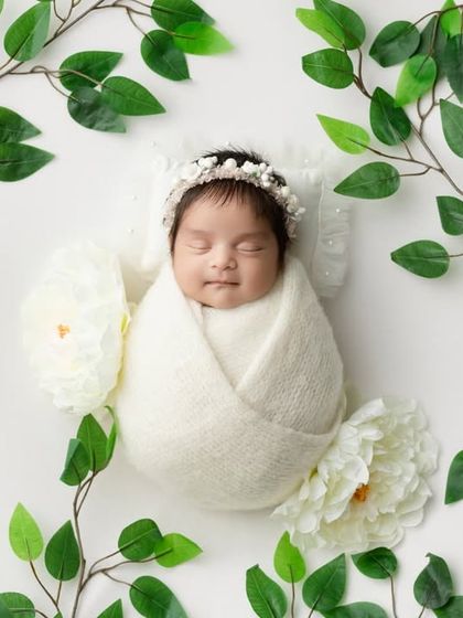 A wider angle of the greenery theme, creating a beautiful, natural frame around the sleeping baby.
