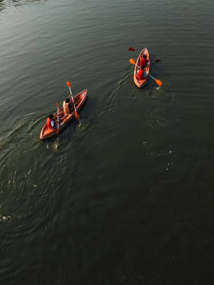 A beautiful top-down view of two kayaks, showcasing the vibrant colors of the boats against the dark water.