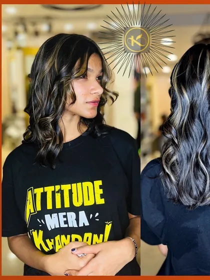 A cool, edgy look with silver and blonde highlights on dark, wavy hair. The client's "Attitude" t-shirt perfectly matches the vibe of her new hairstyle.