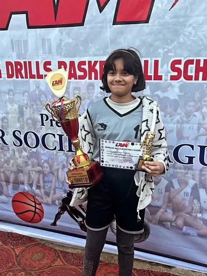 A young player proudly displaying her trophies and certificate. We aim to build confidence in every child.