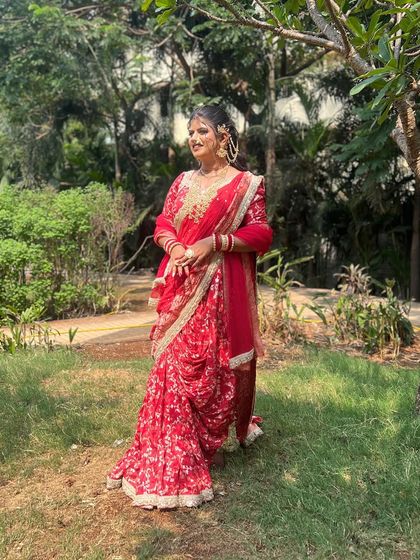 A bride in a red indo-western saree, perfect for a pre-wedding event or reception.