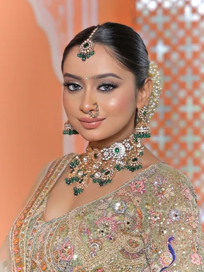 A close-up focusing on the bride's radiant face, with the maang tikka and necklace perfectly framed.