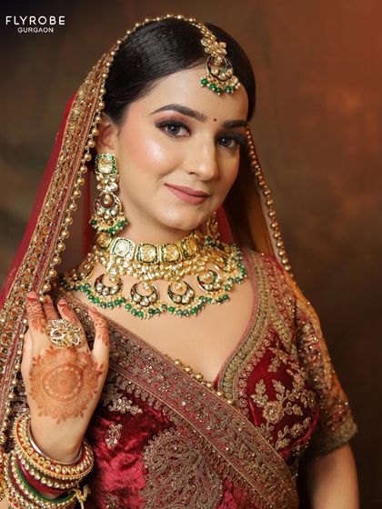 The final touch. This bridal look is completed with a stunning Kundan and emerald jewellery set that perfectly complements the rich velvet lehenga.