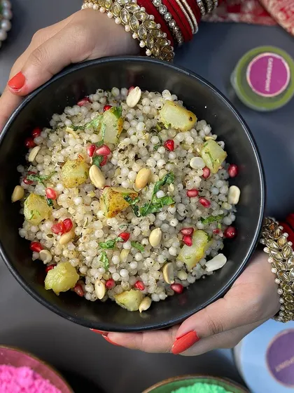 Holding a bowl of our festive Sabudana Khichdi. It's prepared with care, keeping traditions in mind, making it the perfect meal for your Navratri celebrations.