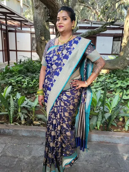Draping for a client in a beautiful blue Banarasi saree. The pleated pallu is a classic South Indian style that is both neat and elegant.