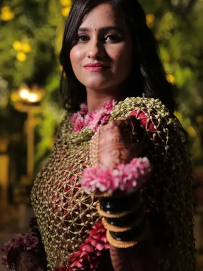 A close-up of the bride holding her floral shela. The intricate details and fresh flowers make it a piece of wearable art.