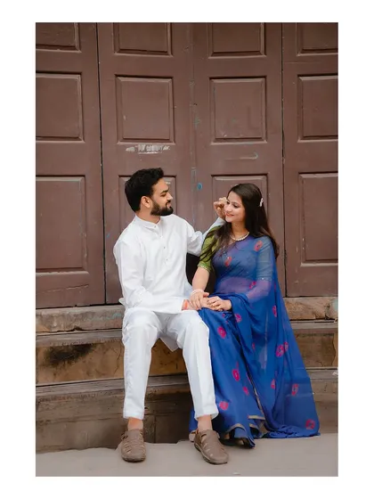 A relaxed portrait of the couple sitting on steps, sharing a quiet moment of conversation and connection.