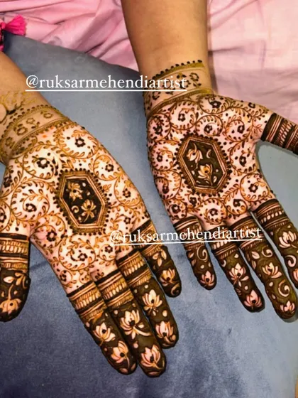 A unique bridal design featuring a central lotus motif in a geometric frame, with matching lotus details on the fingers.