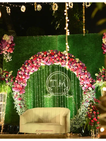 This photo backdrop is a perfect circle of floral beauty. The ring of vibrant flowers creates a stunning frame for photos, with a custom monogram and soft lighting for a personalized touch.